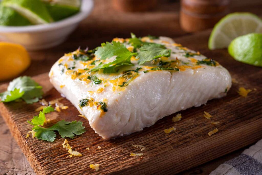 Beautiful slab of cooked halibut ready to eat. Prepare on your own or enjoy at Seascape.