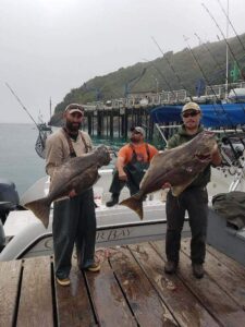 Two fishermen hold up their Halibut fish after the all day halibut and rockfish trip.